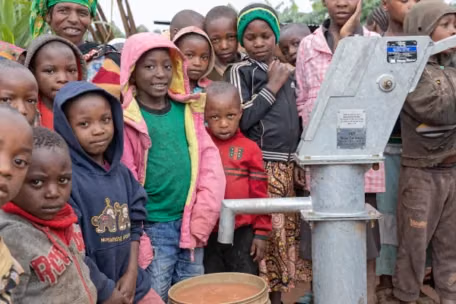Rythm 17 a group of people standing in front of a water pump