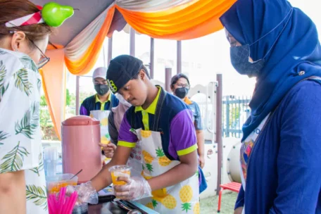 a man serving a cup of juice