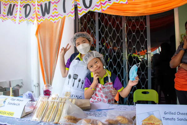 two girls posing for the camera while one holds a facemask