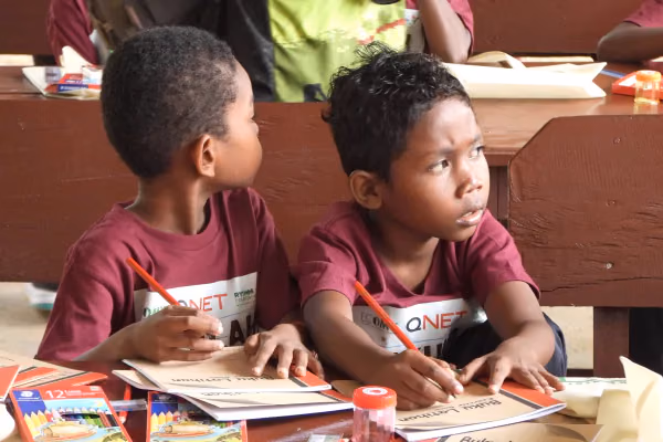 Rythm 13 children holding pencils over a closed notebook while spacing out