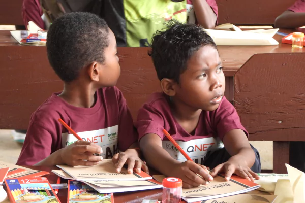 children holding pencils over a closed notebook while spacing out