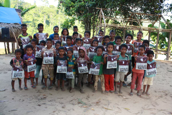 young children standing together looking at the camera